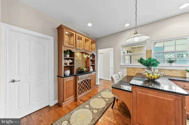 a living room with stainless steel appliances granite countertop furniture and a wooden floor