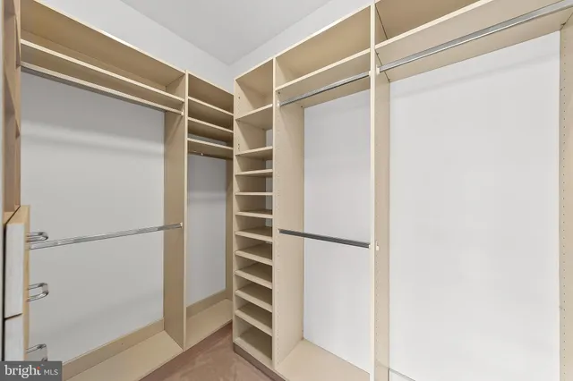 a view of walk in closet with empty racks