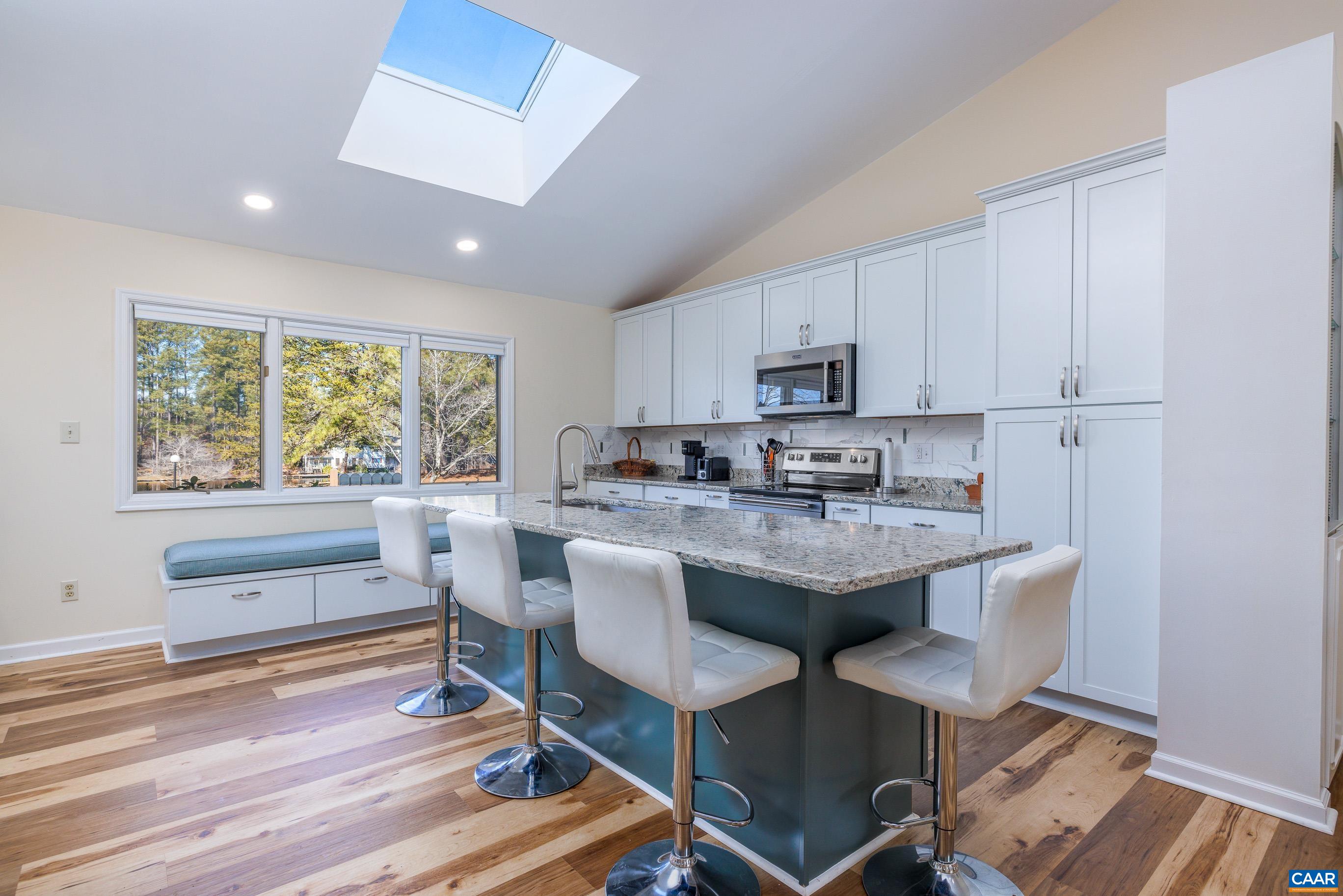 B3 Marina Point Palmyra, VA 22963 - Photo 6 of 47 a kitchen with kitchen island granite countertop wooden floors and white cabinets