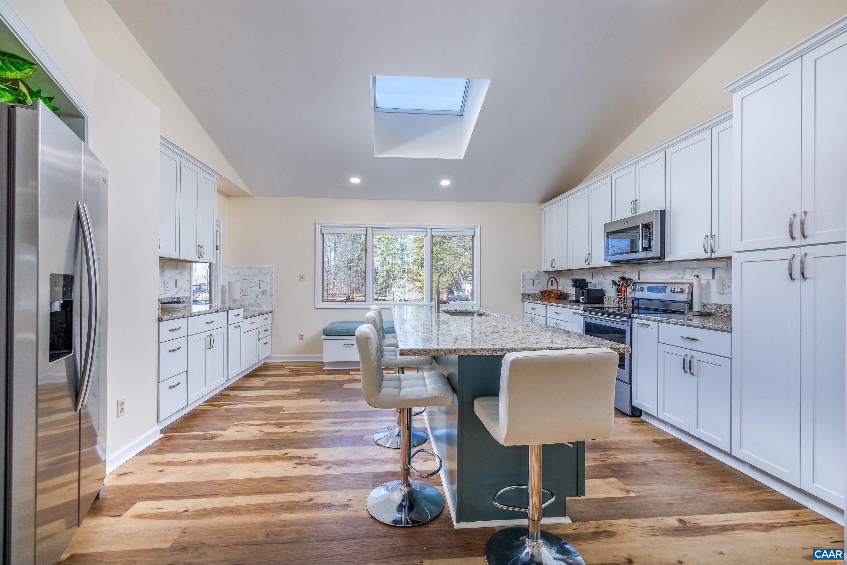 B3 Marina Point Palmyra, VA 22963 - Photo 8 of 47 a kitchen with stainless steel appliances granite countertop a stove top oven a refrigerator a dining table and chairs with wooden floor