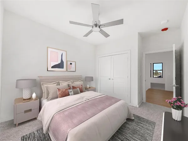 a bedroom with a bed a window and a flat screen tv