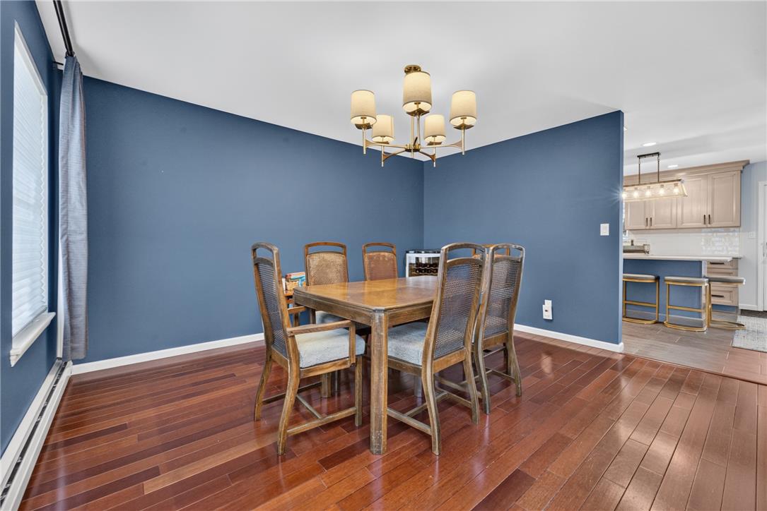 220 Pennbrook Road Stroudsburg, PA 18360 - Photo 14 of 60 Hardwood flooring extends throughout this dining area, illuminated by a classic chandelier.