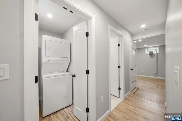 a view of a hallway with wooden floor and a bathroom