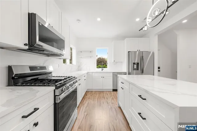 a kitchen with stainless steel appliances a stove a sink and a refrigerator