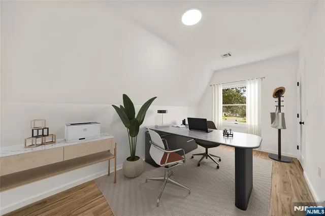 a view of a workspace with furniture and a window