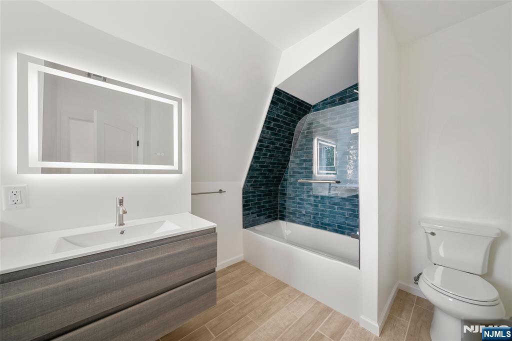 174 Pleasant Avenue Bergenfield, NJ 07621 - Photo 9 of 18 a bathroom with a sink a toilet and shower