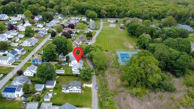 a front view of a house with a yard and potted plants
