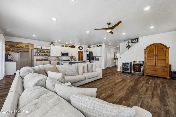 a view of a kitchen with wooden floor and electronic appliances