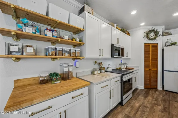 a spacious bedroom with a bed and wooden floor