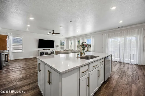 a spacious bedroom with a bed and a dresser with wooden floor