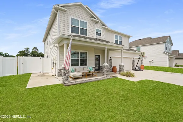 a living room with furniture floor to ceiling window and potted plants