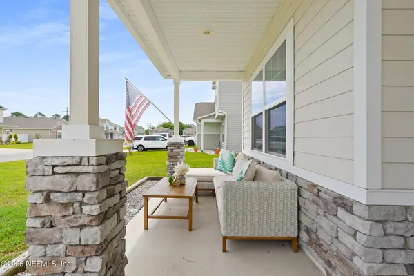 a hallway with wooden floor and a potted plant