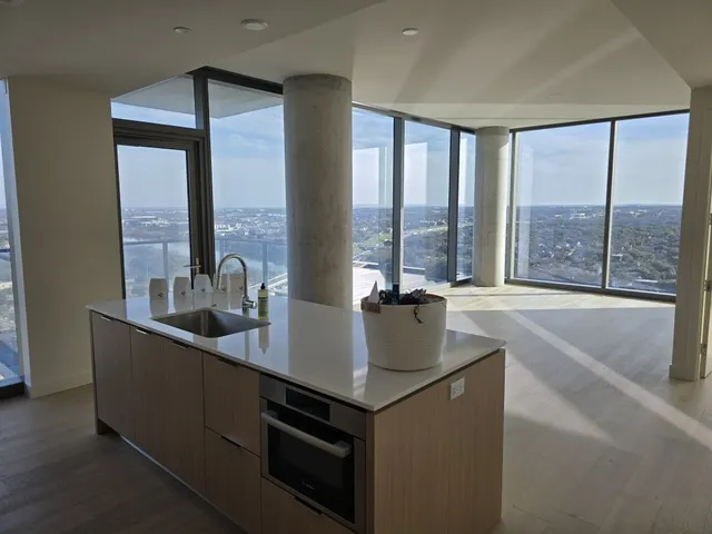a living room with stainless steel appliances granite countertop a sink a stove and a refrigerator