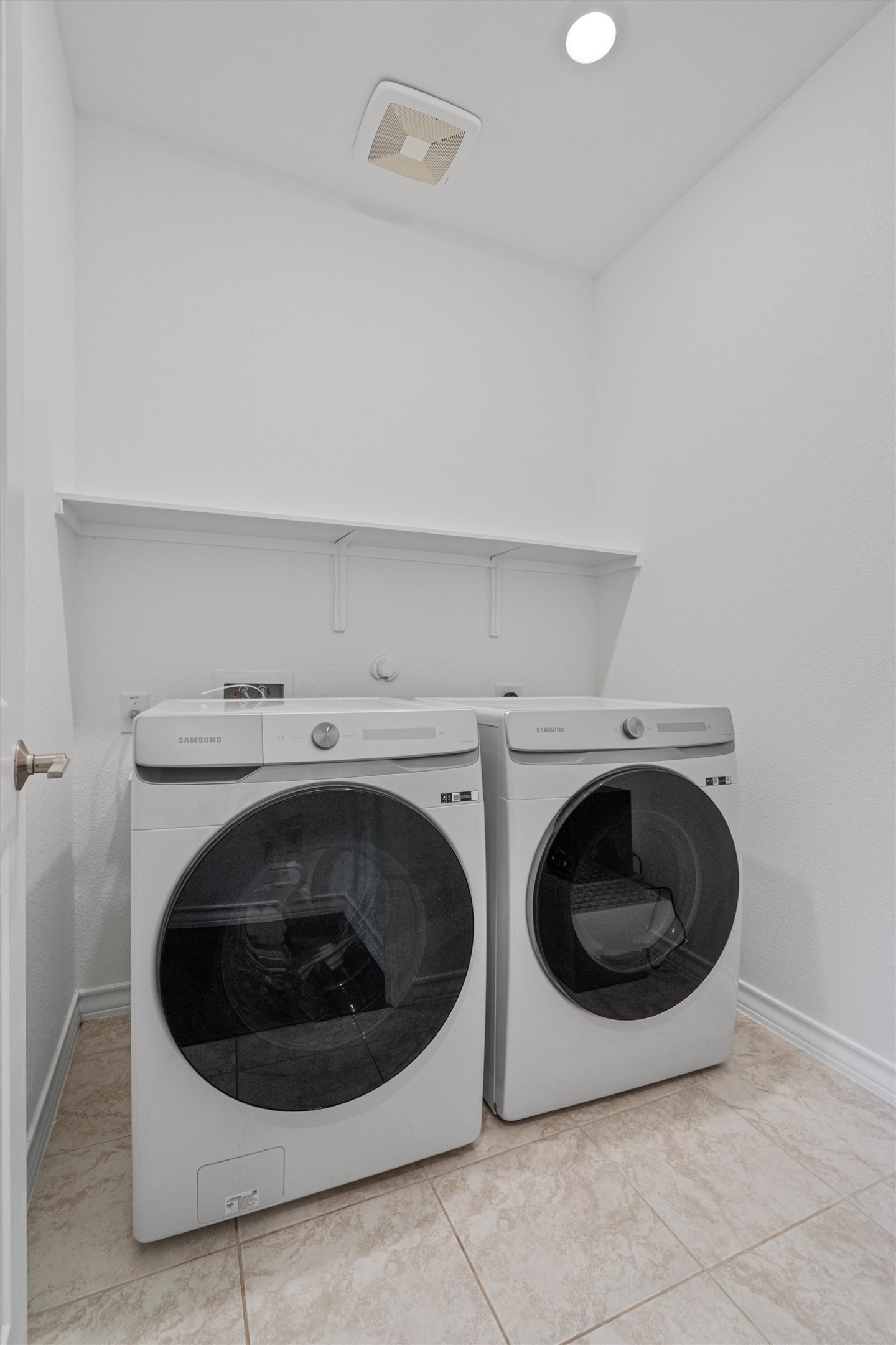 104 Stinchcomb Road Hutto, TX 78634 - Photo 21 of 40 The spacious laundry room includes a stylish white HE washer and dryer that convey, offering both function and convenience with plenty of room for everyday use.