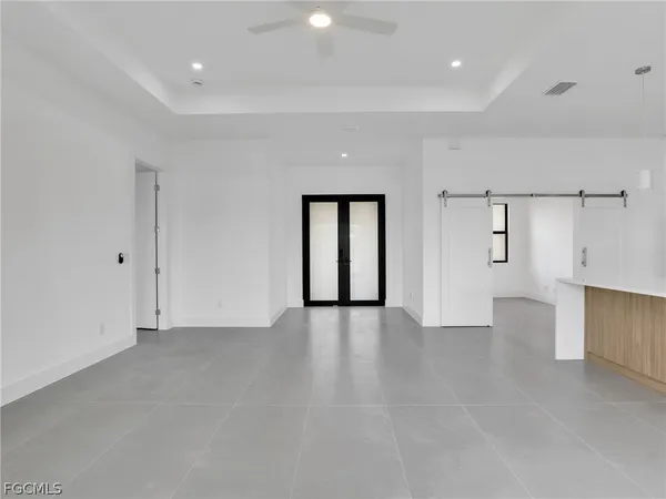 a view of an empty room with wooden floor and windows