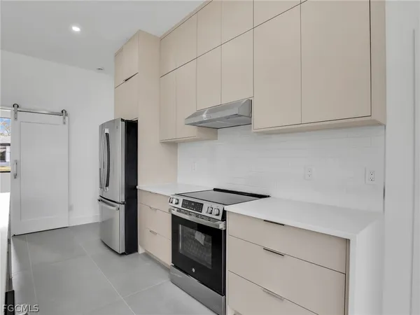 a kitchen with stainless steel appliances granite countertop a refrigerator and a stove
