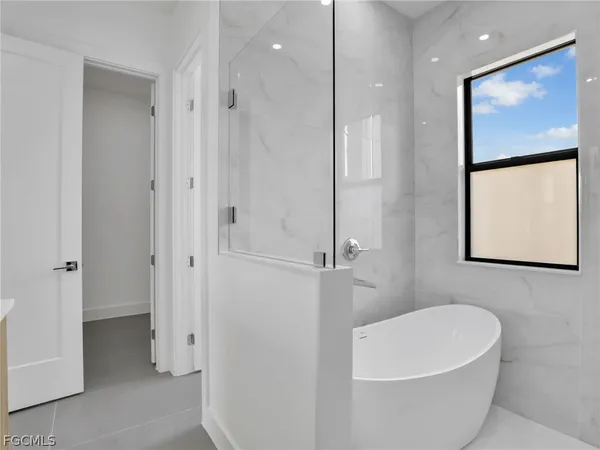 a white bath tub sitting next to a shower