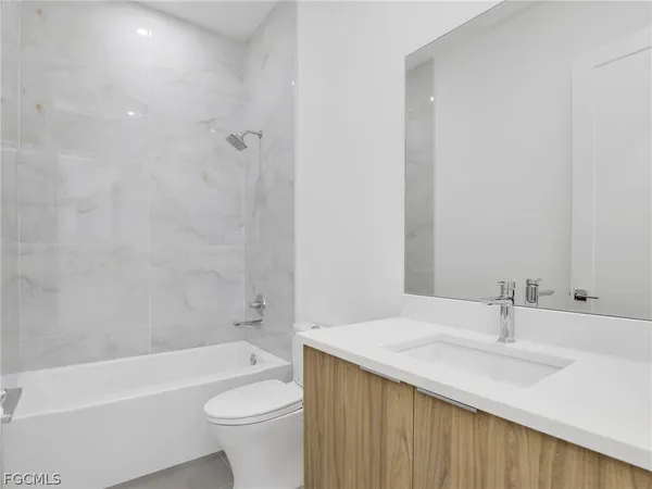 a bathroom with a granite countertop sink a toilet and shower