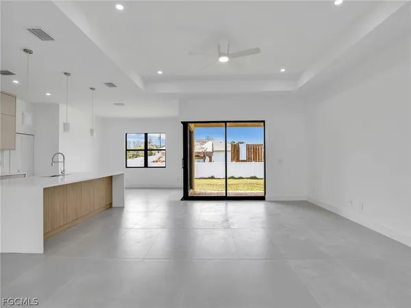 a view of an empty room with window and cabinet