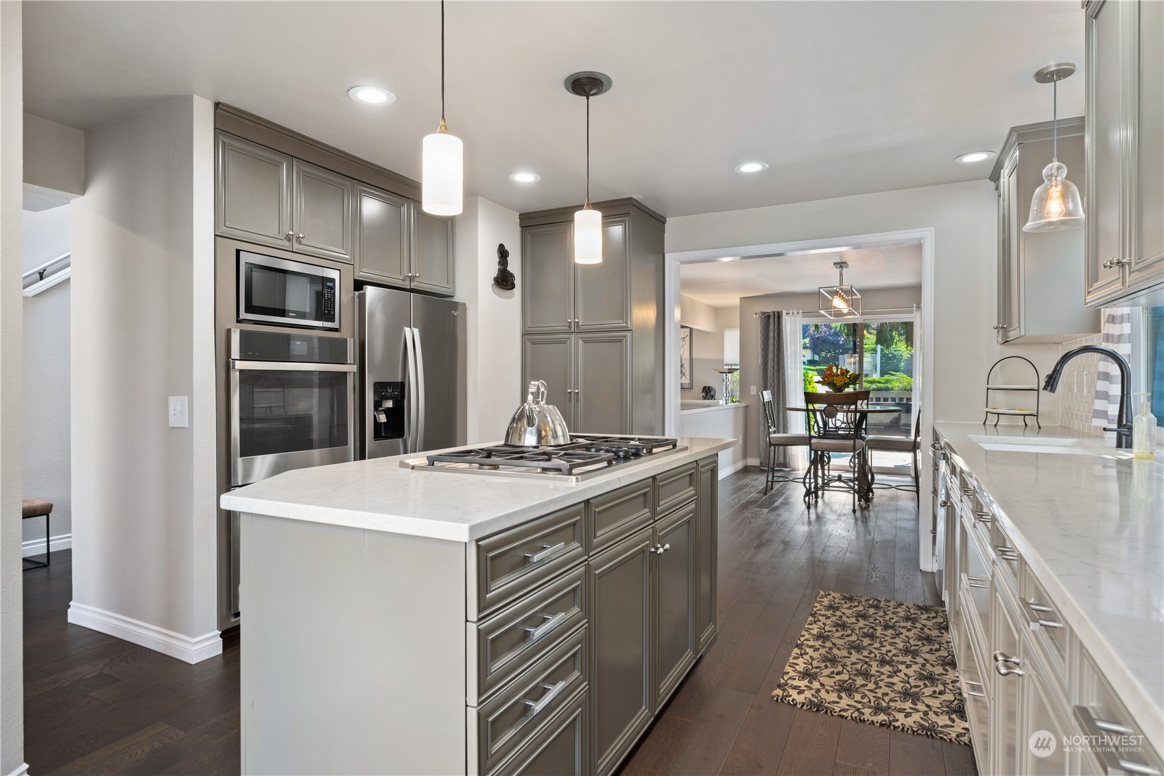 2900 Kennewick Place Northeast Renton, WA 98056 - Photo 13 of 40 a kitchen with a stove a refrigerator and a dining table with wooden floor