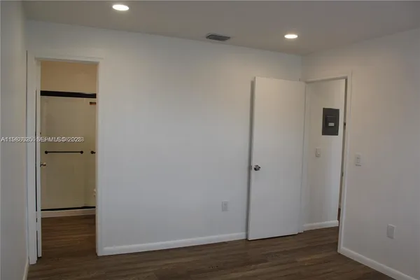 a view of an empty room with wooden floor