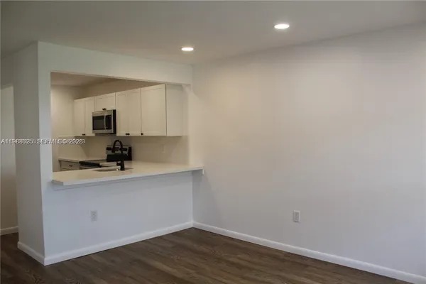 a view of a kitchen with wooden floor and a sink