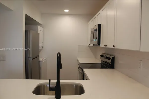 a kitchen with a sink and a refrigerator
