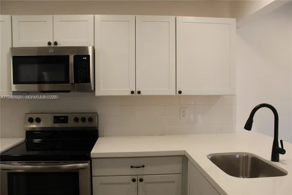 a kitchen with a sink and a stove top oven