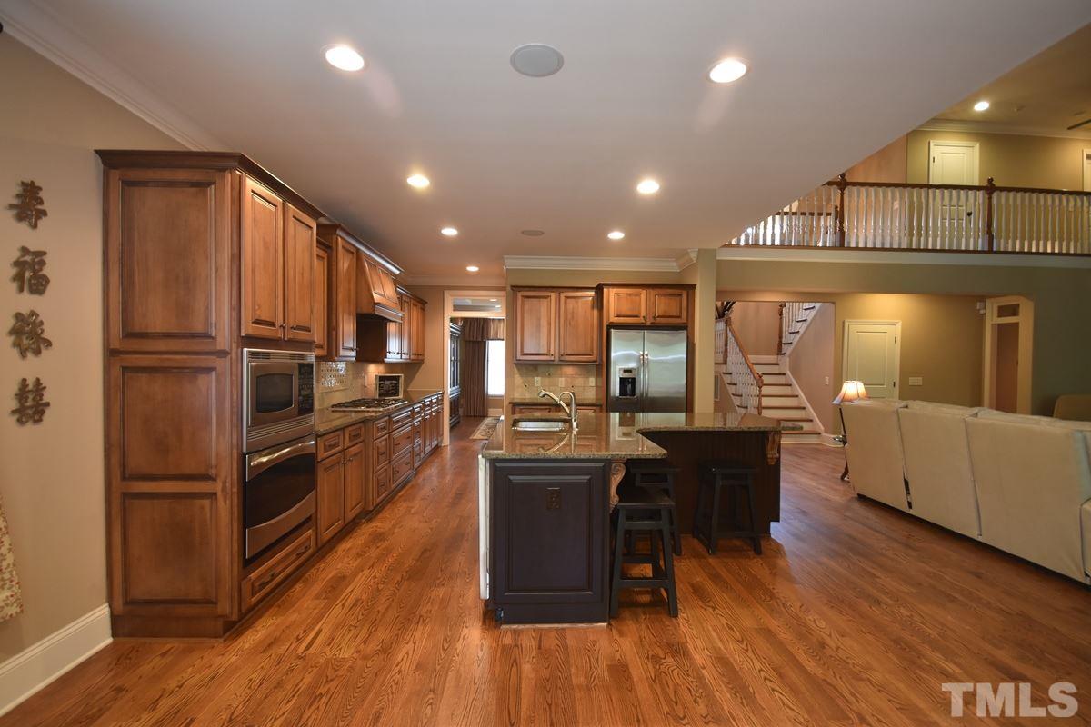 4012 Limerick Road Burlington, NC 27215 - Photo 6 of 24 a open kitchen with stainless steel appliances granite countertop a refrigerator a stove top oven a dining table and chairs with wooden floor