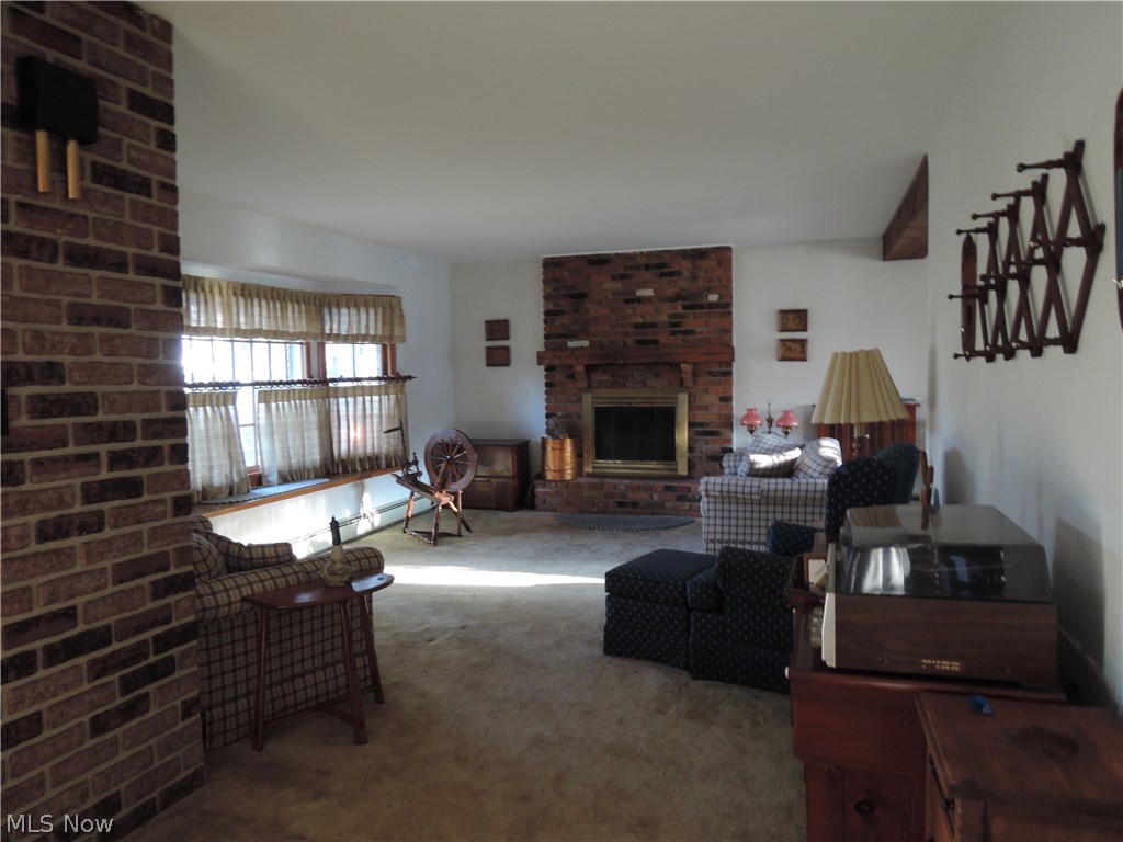 11960 Summers Road Chesterland, OH 44026 - Photo 2 of 17 Spacious living room with a large bay window, neutral carpet, and a fireplace.