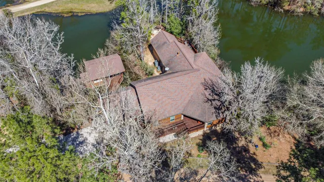 an aerial view of a house with a yard and lake view