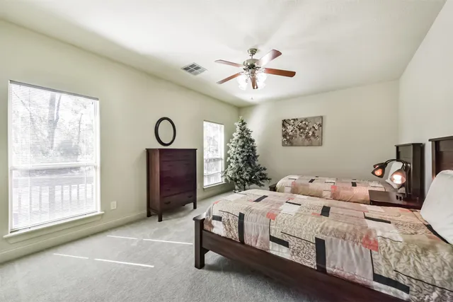 a bedroom with a bed a chandelier and a window