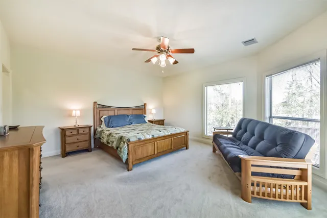 a bedroom with furniture and a large window