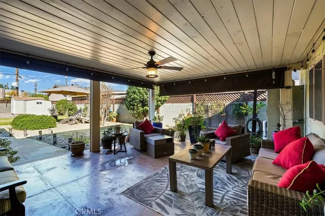 a living room with patio furniture and a potted plant