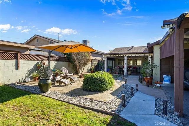 a view of a house with backyard water fountain and sitting area