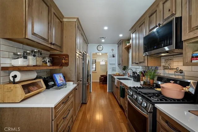 a kitchen with stainless steel appliances granite countertop a sink stove and refrigerator