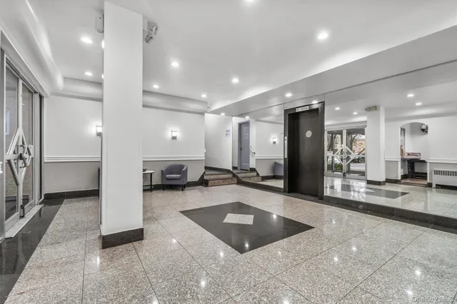 a large hall with a large window and kitchen view