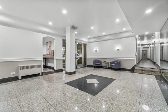a room with lots of furniture and a view of kitchen