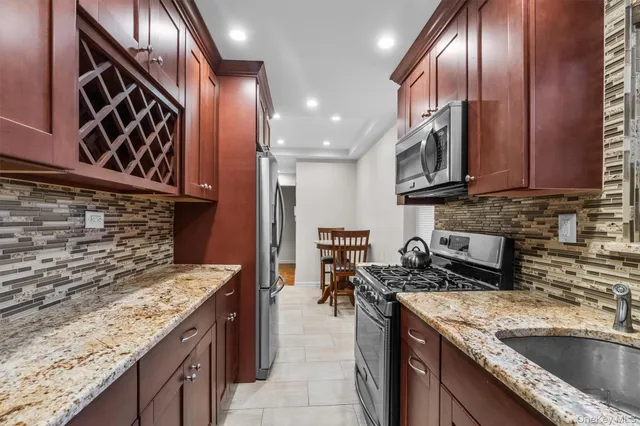 a kitchen with stainless steel appliances granite countertop a sink a stove oven and cabinets