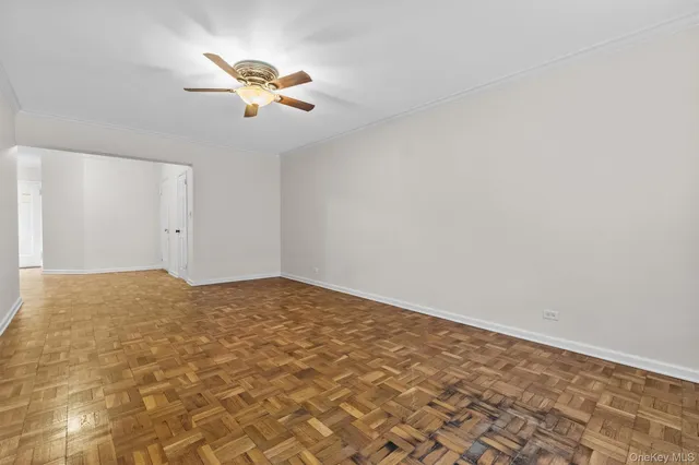 an empty room with a ceiling fan and window