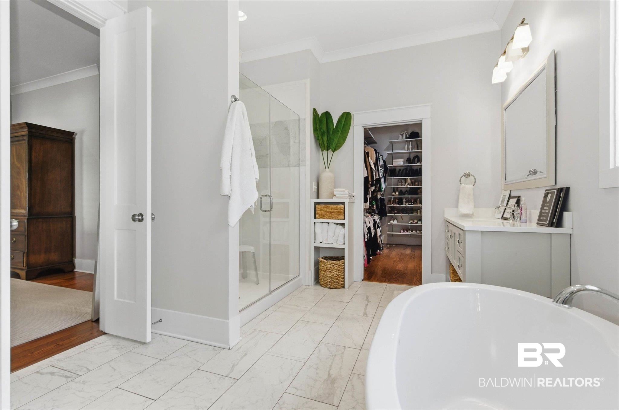 3704 Stein Street Mobile, AL 36608 - Photo 17 of 37 Full bathroom featuring a walk in closet, crown molding, vanity, a freestanding tub, and light marble finish flooring