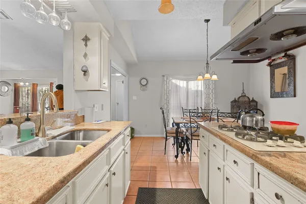 a kitchen with sink stove and cabinets