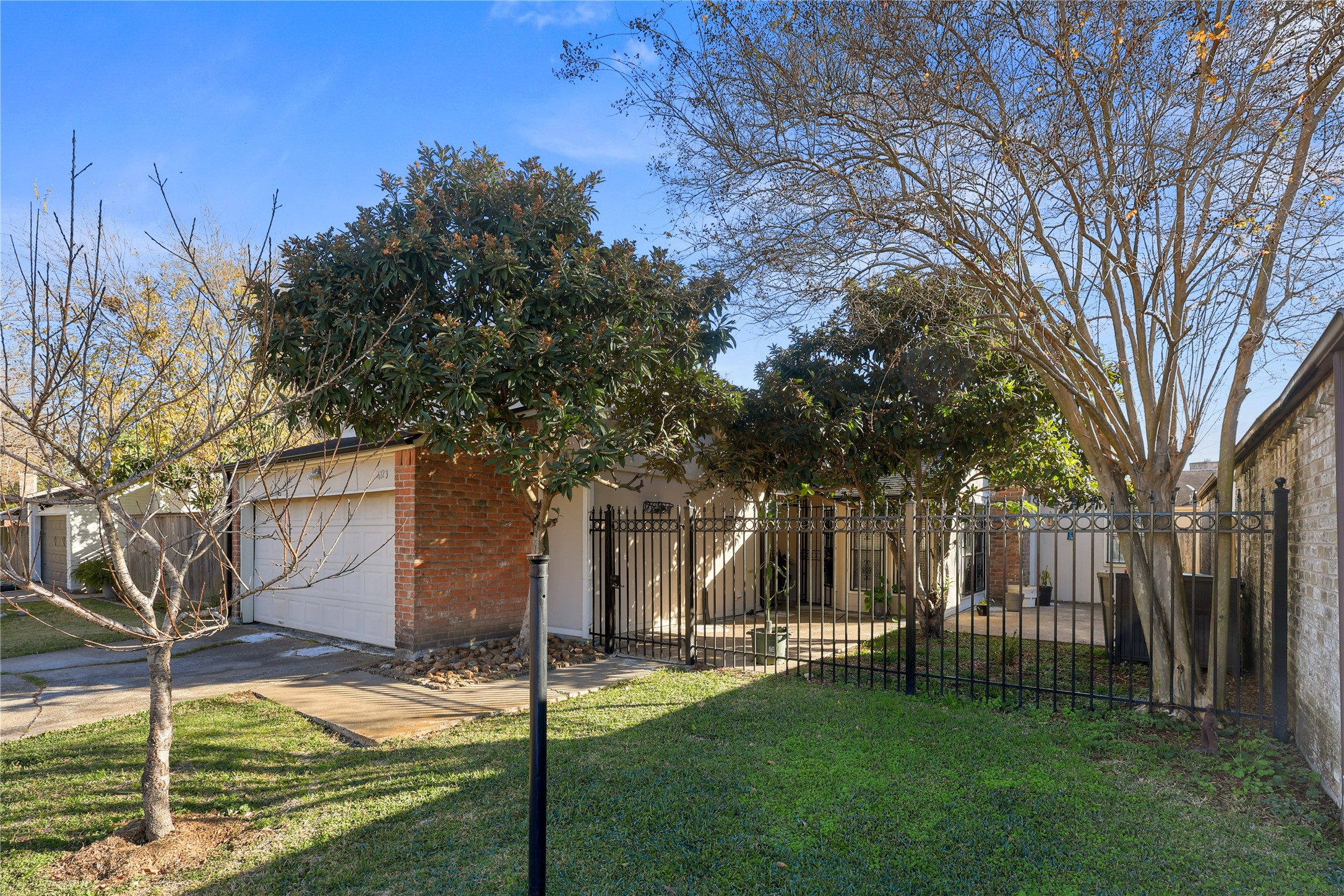 4123 Yupon Ridge Drive Houston, TX 77072 - Photo 2 of 22 Charming home with a brick exterior, featuring a gated entry and lush greenery. The property offers a cozy courtyard area and a two-car garage, providing both privacy and functionality.