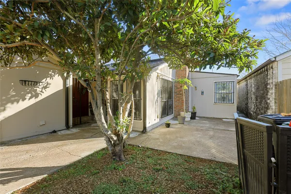 a view of a house with backyard and a tree