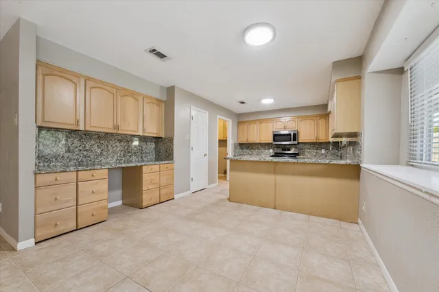 a kitchen with granite countertop white cabinets and stainless steel appliances