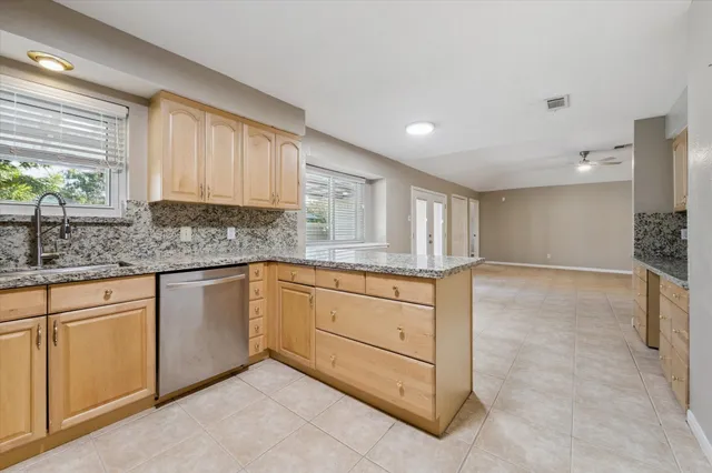 a kitchen with granite countertop a sink and cabinets