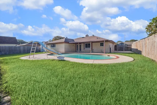 a view of a house with a backyard and a patio