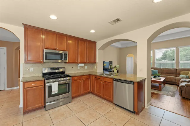 a kitchen with stainless steel appliances granite countertop a sink and cabinets