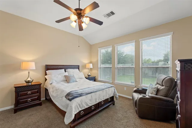 a bedroom with a bed couch and a large window