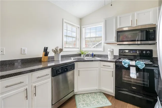 a kitchen with stainless steel appliances granite countertop a stove a sink and a microwave